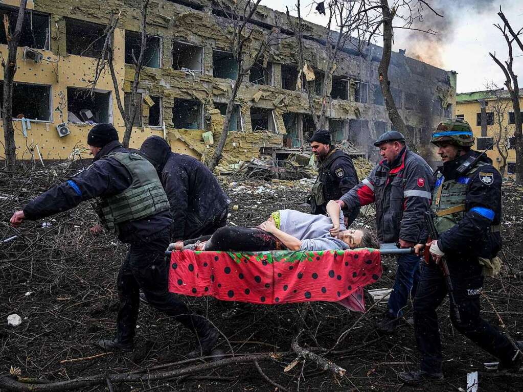 10. Mrz: Ukrainische Rettungskrfte und Freiwillige tragen eine verletzte schwangere Frau aus einer Entbindungsklinik, die durch Beschuss in der ukrainischen Stadt Mariupol  beschdigt wurde.