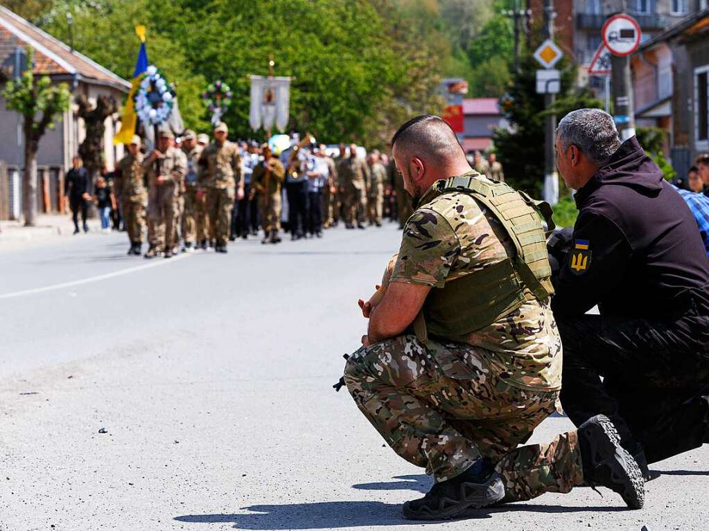 11. Mai: Menschen knien in Velykyi Bereznyi vor der Beerdigungsprozession, um den gefallenen Soldaten Respekt zu erweisen.