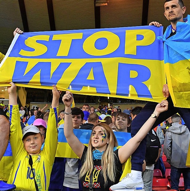 Fans im Stadion zeigen Flagge gegen den Krieg.  | Foto: ANDY BUCHANAN (AFP)
