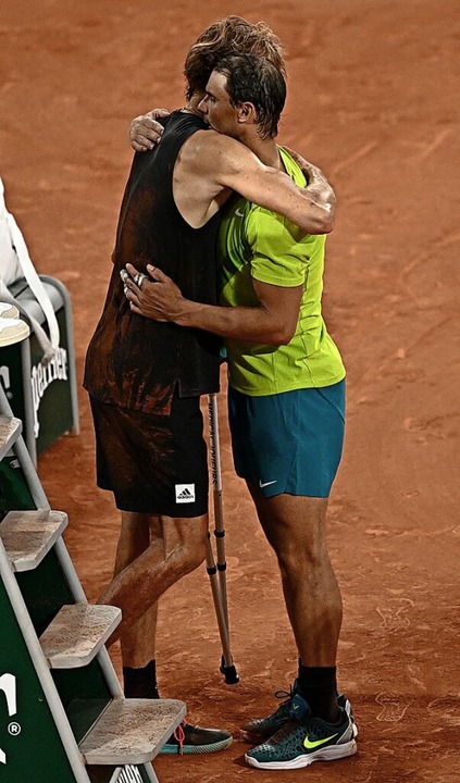 Rafael Nadal nimmt Alexander Zverev in...d versucht, den Deutschen  zu trösten.  | Foto: ANNE-CHRISTINE POUJOULAT (AFP)
