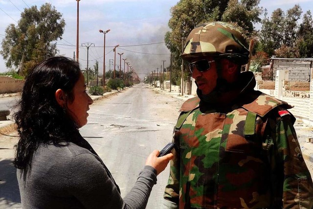 Ein Journalistin spricht mit einem syr...mitten im Kriegsgebiet in Syrien 2013.  | Foto: Sana Handout