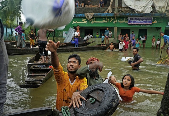 Unter Wasser: Menschen in Companiganj,...nd auf Lebensmittelspenden angewiesen.  | Foto: MARUF RAHMAN (AFP)