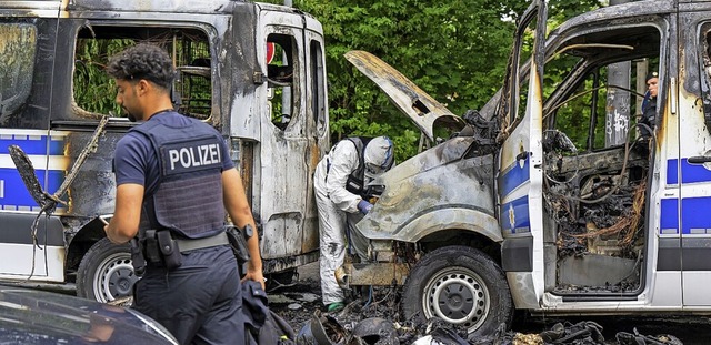 Ermittler der Spurensicherung  an einem ausgebrannten Polizeiauto  | Foto: Peter Kneffel (dpa)