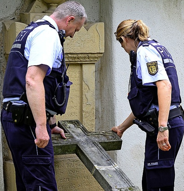 Polizisten inspizieren ein zerstrtes Grabmal.  | Foto: Ingo Schneider