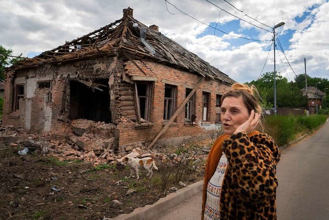 Eine Frau steht im ukrainischen Bachmu...  russischen Beschuss zerstrtes Haus.  | Foto: Efrem Lukatsky (dpa)