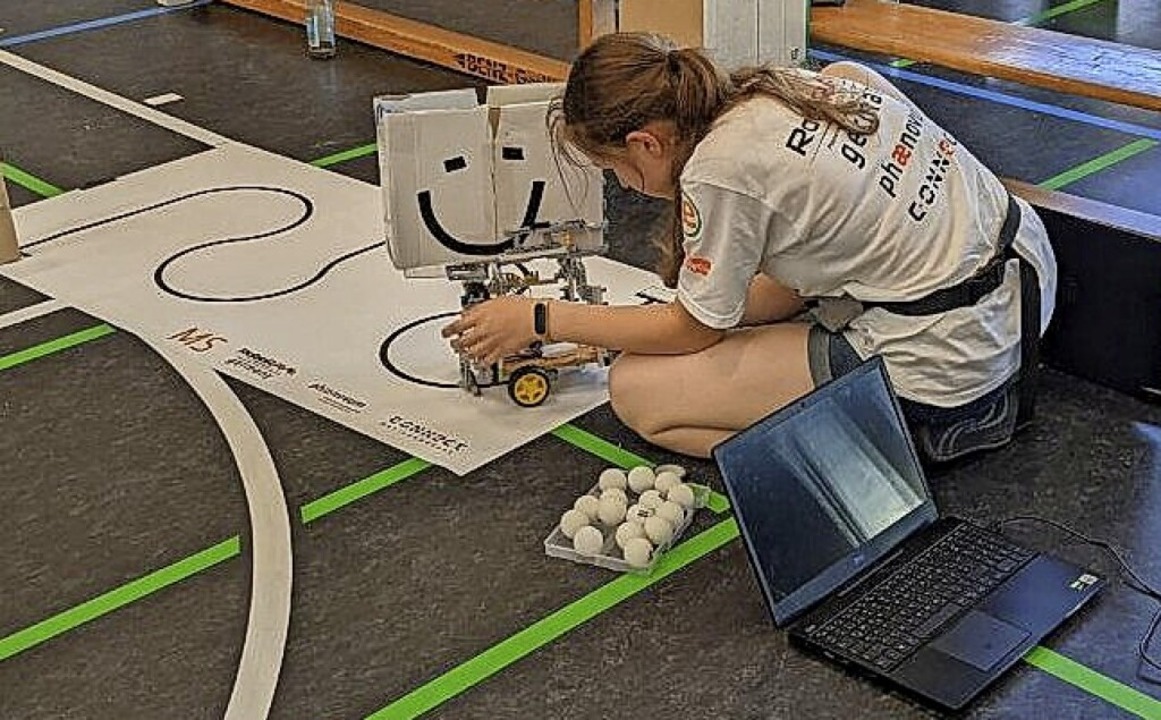 Eine Schlerin berprft ihren Roboter...m Ende der Linie transportieren soll.   | Foto: Aaron Hohenfeld