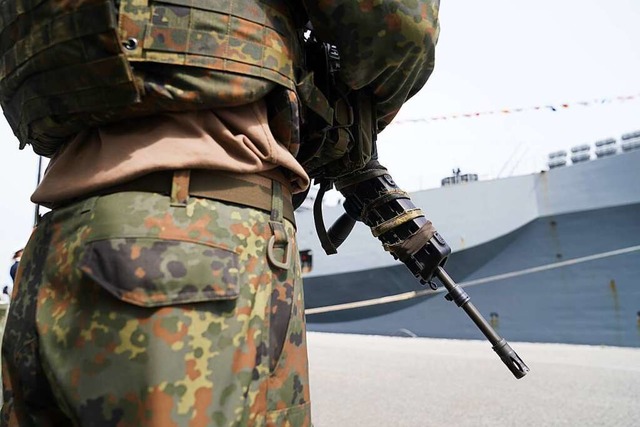 Ein bewaffneter Soldat steht vor dem U...S) im Marinesttzpunkt in Kiel ankert.  | Foto: Marcus Brandt