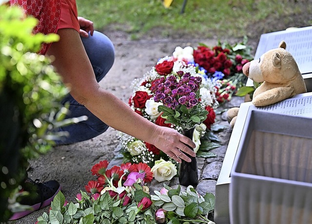 Die Angehrige Ella Karimova aus Russl...gt an der Gedenksttte Blumen nieder.   | Foto: Felix Kstle (dpa)