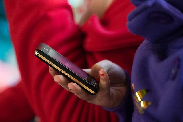 Eine Schlerin hlt ein mobiles Telefo...egistrierte die Polizei  2021 in Wyhl.  | Foto: Armin Weigel (dpa)