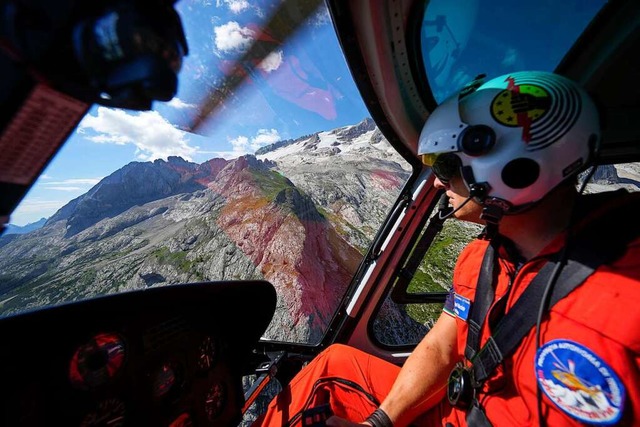 Ein Retter steuert einen Hubschrauber,... in den italienischen Alpen zu suchen.  | Foto: Luca Bruno (dpa)