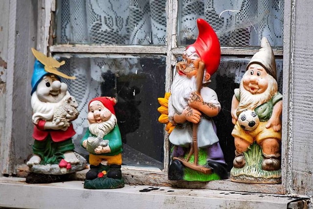 Eine Gruppe Gartenzwerge steht auf einer Fensterbank in einem Garten.  | Foto: Stefan Sauer (dpa)