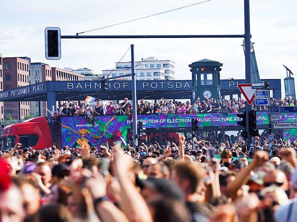 Unter dem Motto Rave the Planet zieht eine Parade aus Technofans tanzend am Potsdamer Platz vorbei.