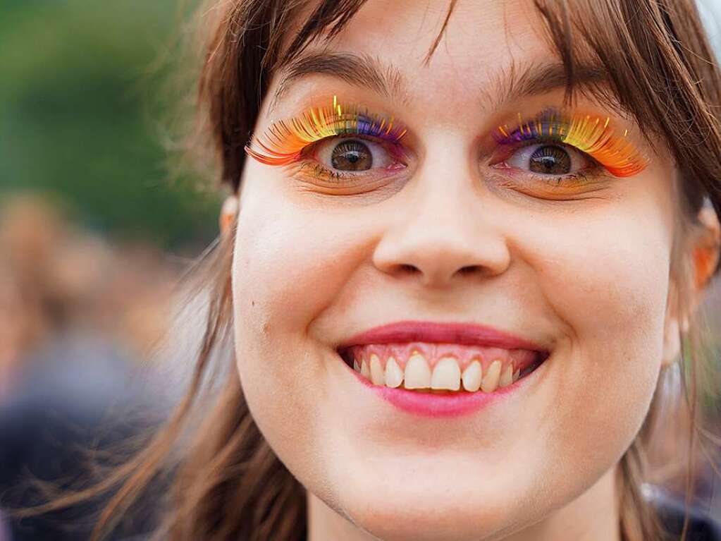 Mit aufflligen Regenbogenwimpern nimmt eine Frau an der Rave the Planet Parade teil.