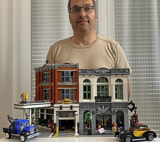 Volker Betz mit zwei Lego-Modellhusern und passenden Autos  | Foto: privat