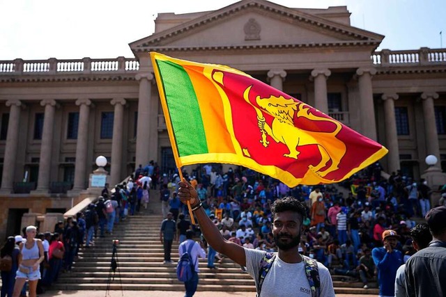 Ein Demonstrant schwenkt eine National... Rajapaksa vor seinem Bro in Colombo.  | Foto: Eranga Jayawardena (dpa)