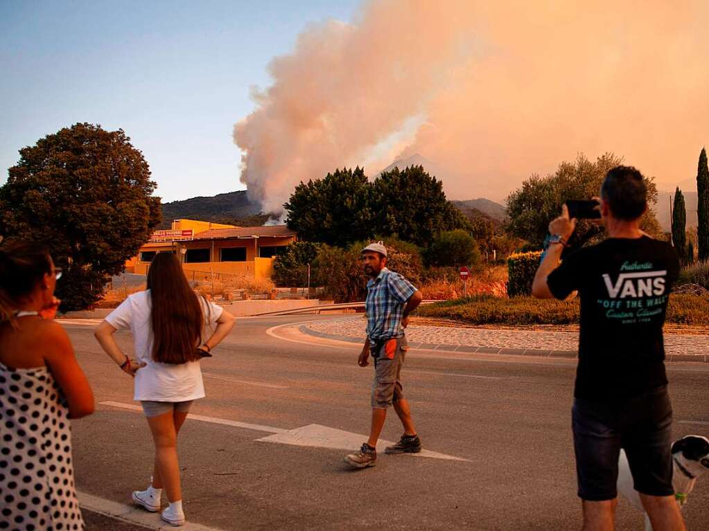 Menschen beobachten den Rauch eines Waldbrands in der spanischen Provinz Malaga.