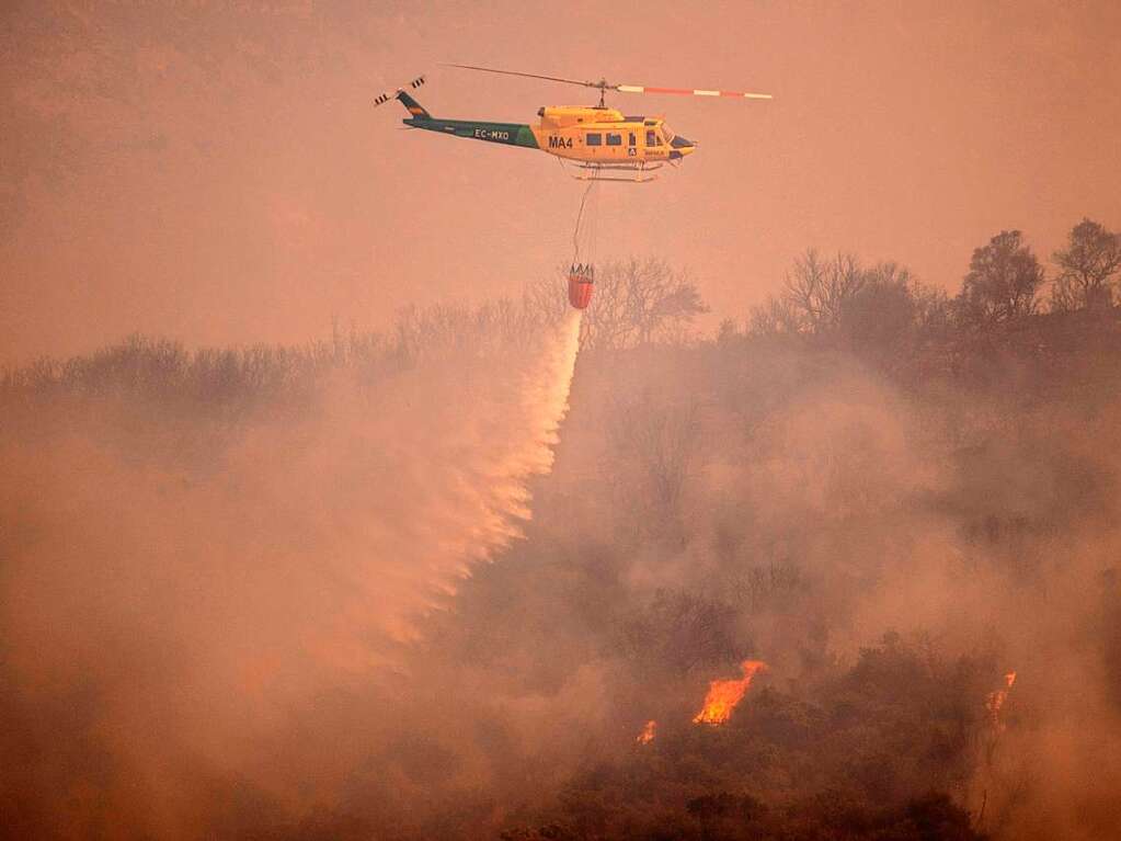 Ein Hubschrauber lscht aus der Luft einen Waldbrand im spanischen Sierra de Mijas in der Provinz Malaga.