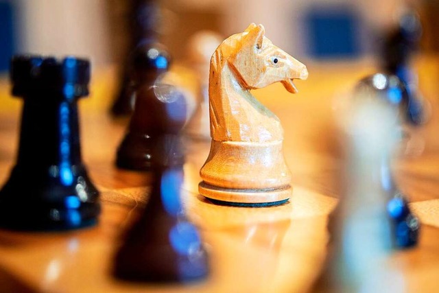 Die Schachfigur eines Springers und an...aus Holz stehen auf einem Schachbrett.  | Foto: Hauke-Christian Dittrich (dpa)