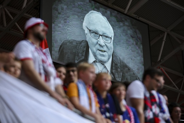 Zuschauer und Spieler gedenken Uwe Seeler, der auf eine Videotafel zu sehen ist.  | Foto: Jan Woitas (dpa)