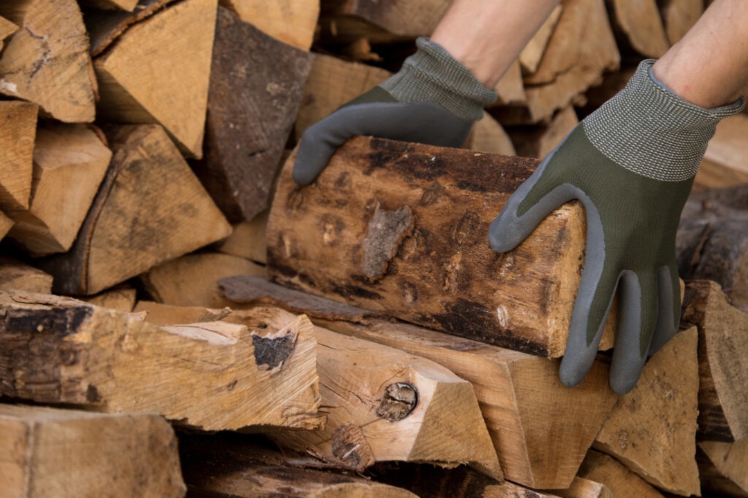 Gesägtes und gespaltenes Brennholz lagert auf einem Stapel.  | Foto: Christin Klose (dpa)