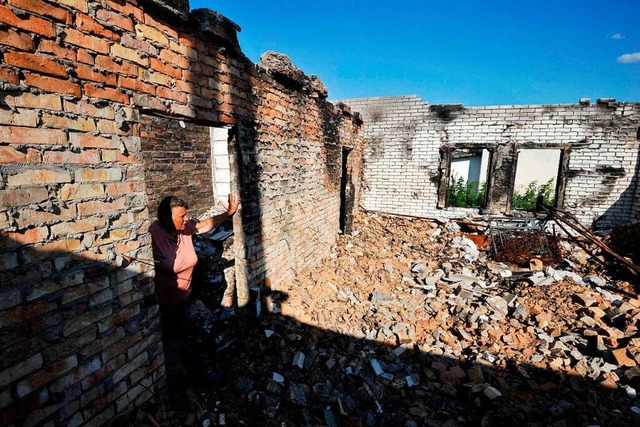 Eine Frau steht am Donnerstag in ihrem...us im Dorf Moschun, nrdlich von Kiew.  | Foto: SERGEI CHUZAVKOV (AFP)