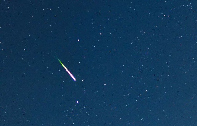 Eine Sternschnuppe leuchtet am Nachthimmel.  | Foto: Patrick Pleul (dpa)