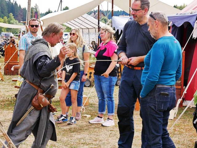 Ein Ritter zeigt Erwachsenen, wie weit...n am Bauch ein Schwert angesetzt wird.  | Foto: Eva Korinth