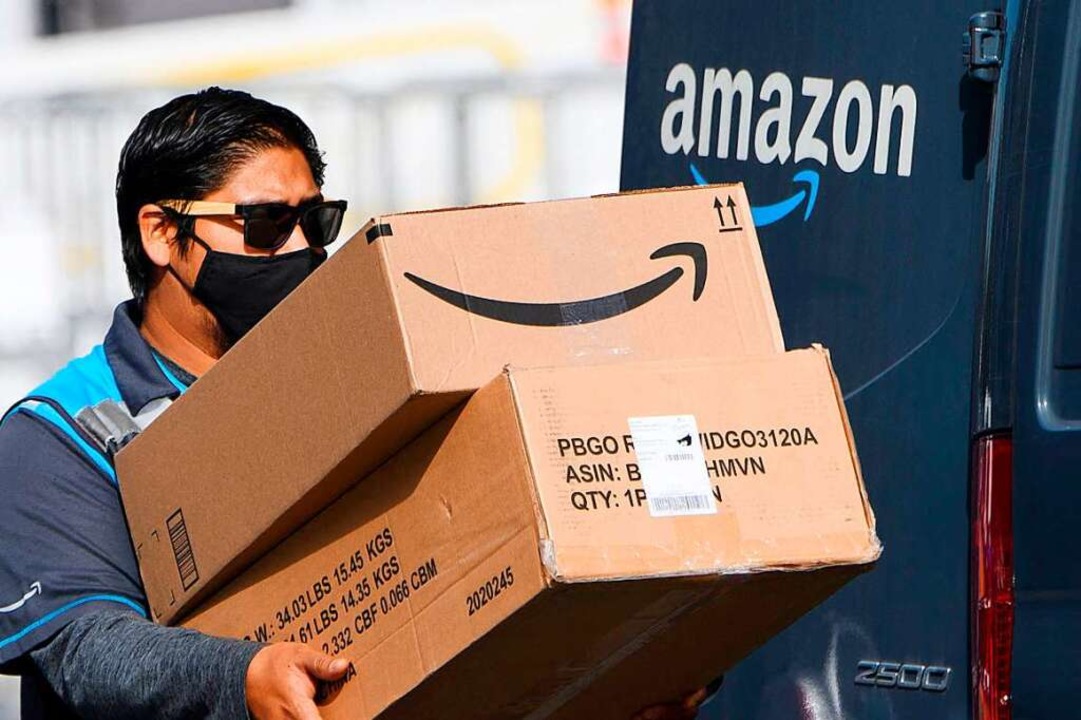 Ein Fahrer liefert Amazon-Pakete aus &...ndler oft externe Logistikunternehmen.  | Foto: PATRICK T. FALLON (AFP)