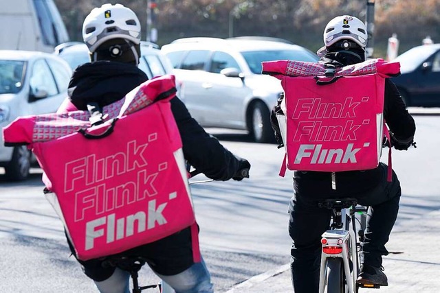 Zwei Fahrradkuriere tragen Ruckscke m...des Lebensmittel Lieferdienstes Flink.  | Foto: Sebastian Kahnert (dpa)