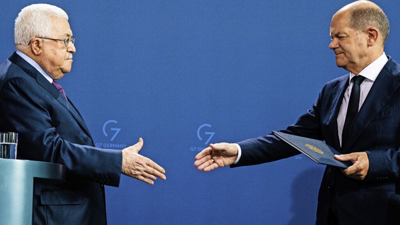 Bundeskanzler Scholz und Palästinenser... reichen sich nach dem Eklat die Hand.  | Foto: JENS SCHLUETER (AFP)