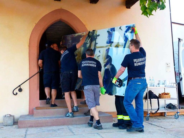 Angehrige der Rmminger Feuerwehr tru...m schwere Glaskunstwerk in die Kirche.  | Foto: Anneliese Gastel