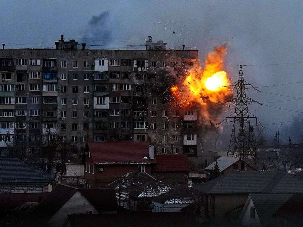 Eine Explosion ist in einem Wohnhaus zu sehen, nachdem ein Panzer der russischen Armee geschossen hat.