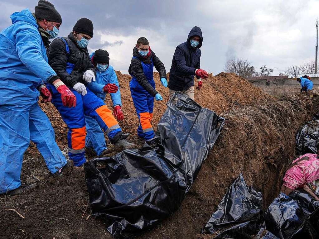 Tote werden in ein Massengrab am Rande der ukrainischen Stadt Mariupol gelegt, da die Menschen ihre Toten wegen des schweren Beschusses durch die russischen Streitkrfte nicht begraben knnen.