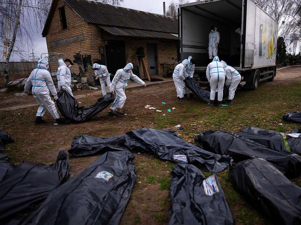 Freiwillige laden die Leichen der in Butscha getteten Zivilisten auf einen Lastwagen, um sie zur Untersuchung in ein Leichenschauhaus zu bringen.