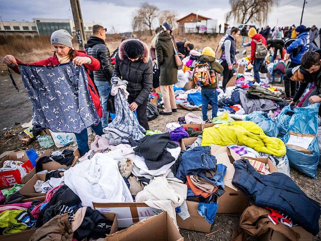 Geflchtete aus der Ukraine suchen nach ihrem Grenzbertritt von Schehyni in der Ukraine nach Medyka in Polen im polnischen Grenzgebiet nach passender Kleidung, die von polnischen Brgern bereitgestellt wurde.