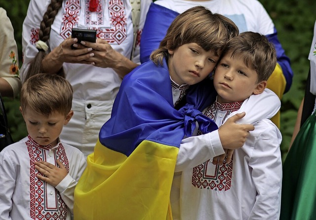 Nachdenkliche Gesichter: Diese ukraini...tstag die Nationalhymne ihres Landes.   | Foto: Michal Dyjuk (dpa)