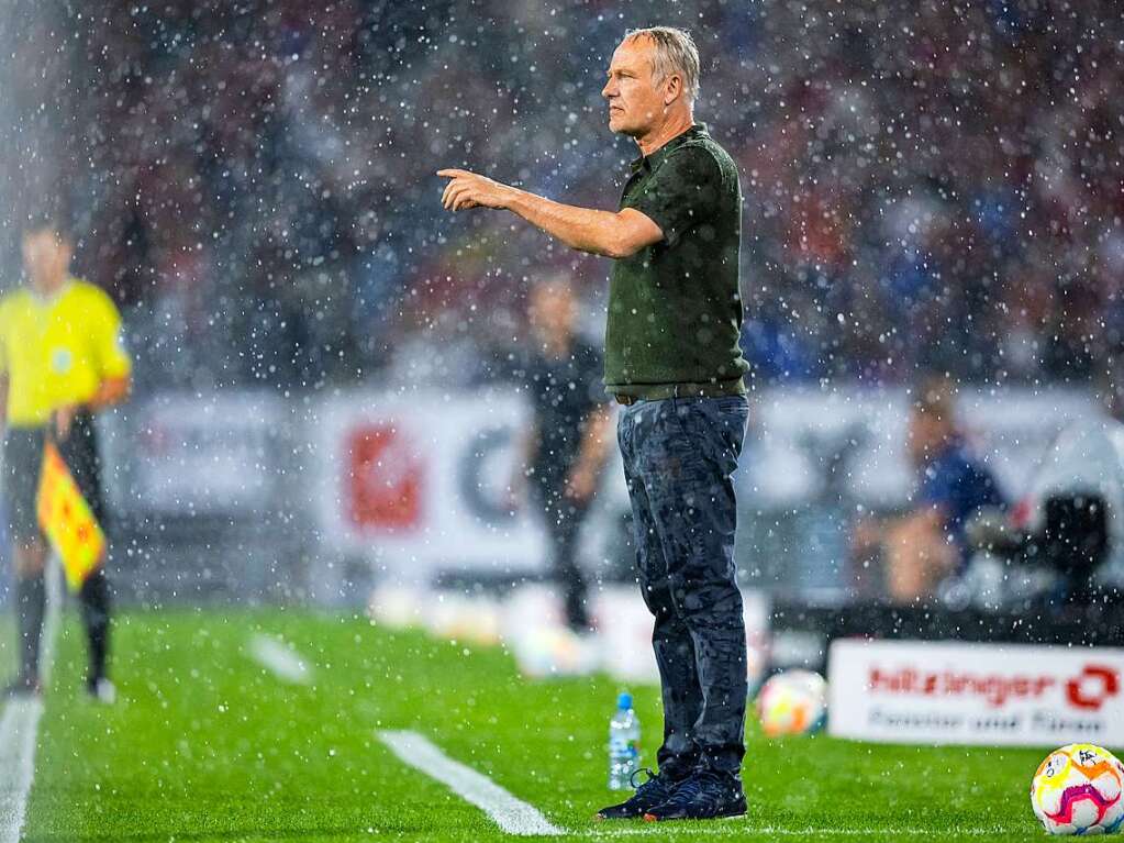 Christian Streich steht im Regen.