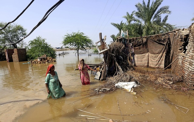 Frauen waten in der pakistanischen Pro...arpur durch ein berschwemmtes Gebiet.  | Foto: Fareed Khan (dpa)