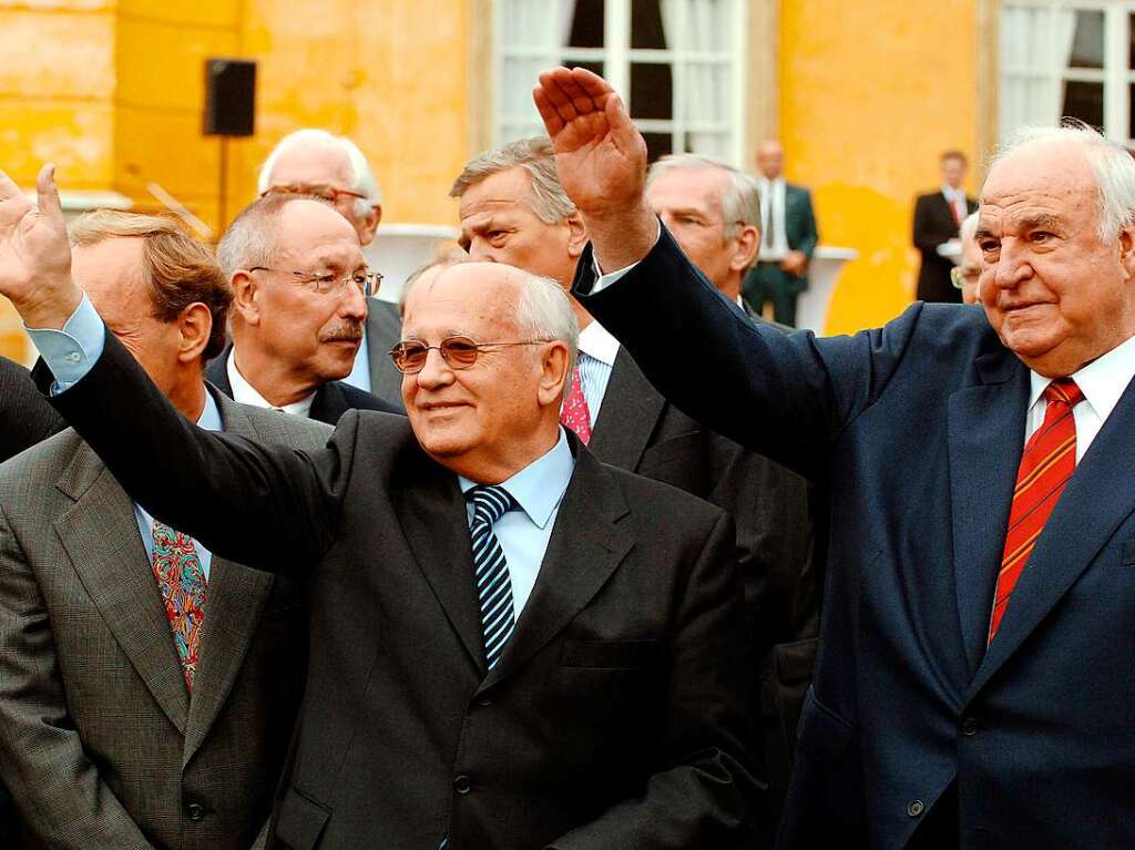 Am Tag der Deutschen Einheit winken der ehemalige sowjetische Prsident Michail Gorbatschow und der damalige Altkanzler Helmut Kohl (r.) im Schlosspark Sanssouci in Potsdam Besuchern der Feierlichkeiten zu.