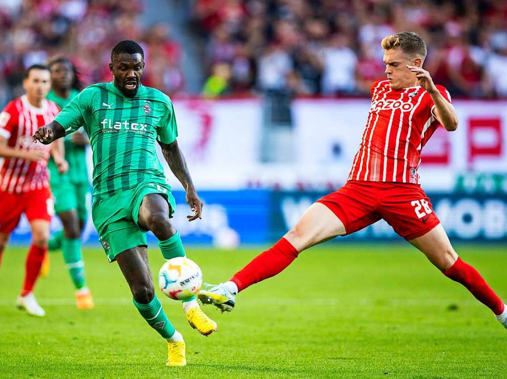 Gladbachs Marcus Thuram  im Zweikampf gegen Freiburgs Matthias Ginter.