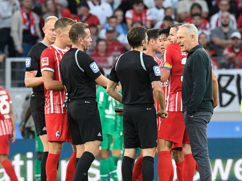 Derweil hat Christian Streich (rechts) Gesprchsbedarf mit dem Unparteiischengespann.