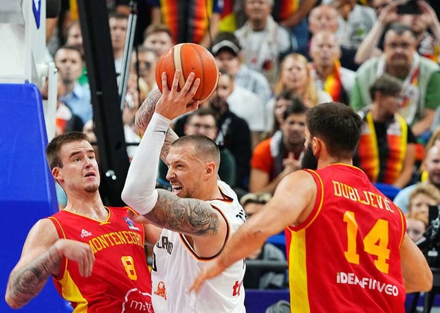 Daniel Theis behauptet den Ball gegen zwei Spieler des Teams aus Montenegro.  | Foto: Soeren Stache (dpa)