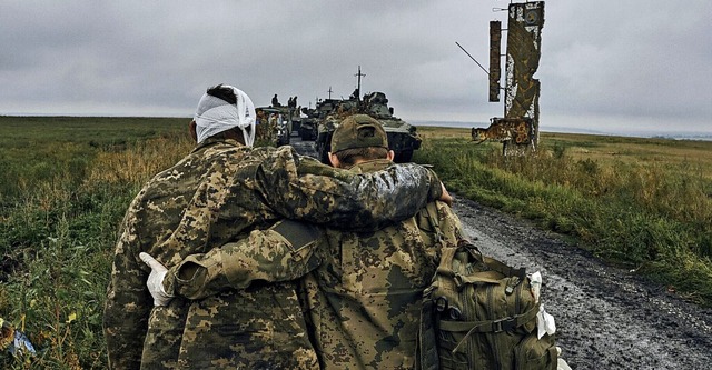 Ein ukrainischer Soldat hilft einem ve...efreiten Gebiet in der Region Charkiw.  | Foto: Kostiantyn Liberov (dpa)