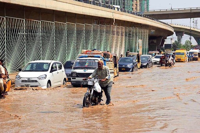 Verkehrsteilnehmer kmpfen sich im pak...Karachi durch eine berflutete Strae.  | Foto: Ppi (dpa)