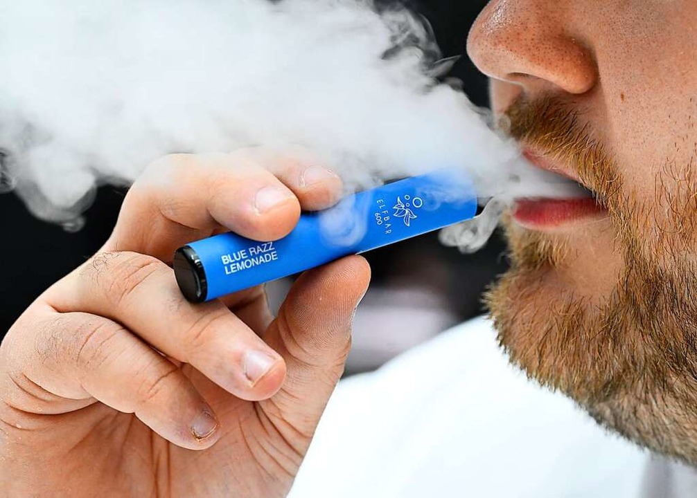 Ein Raucher inhaliert eine Wegwerf-E-Z... nach E-Zigaretten deutlich gestiegen.  | Foto: Roberto Pfeil (dpa)