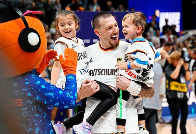 Daniel Theis freut sich mit seinen Kindern und dem EM-Maskottchen.  | Foto: TOBIAS SCHWARZ (AFP)