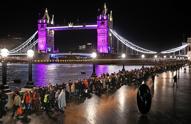 Tausende warteten am Sonntag schon, als es noch dunkel war.  | Foto: OLI SCARFF (AFP)