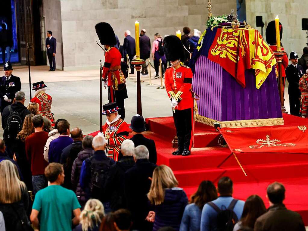 Knigliche Wachen stehen neben dem Sarg der britischen Knigin Elizabeth II., whrend Mitglieder der ffentlichkeit ihr nach ihrem Tod die letzte Ehre erweisen.