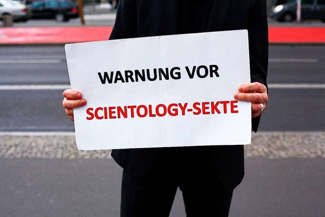 Ein Mann demonstriert aam Rande einer ...t einem Schild gegen die Organisation.  | Foto: Wolfram Steinberg