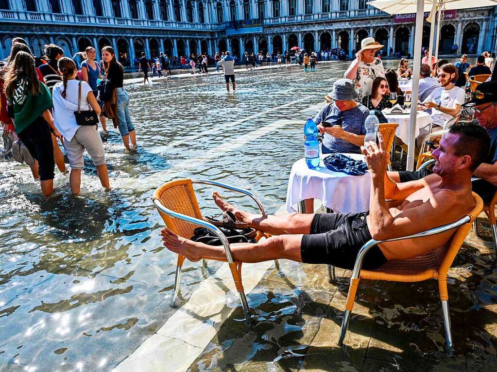 In Venedig stehen manche Straen und Pltze unter Wasser.